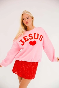 Detail of pink long sleeve sweatshirt with red Jesus text and heart sequin embroidery