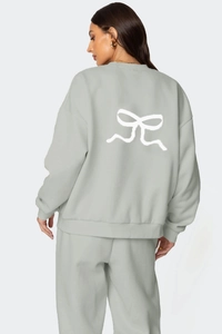 Détail du nœud blanc au dos du sweat-shirt à manches longues vert clair et du pantalon assorti