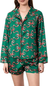 Detail of forest green satin pajama set with red bow prints and button-up front pocket
