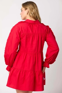Detail of red tiered dress featuring ruffle sleeves, shirt collar and layered skirt back