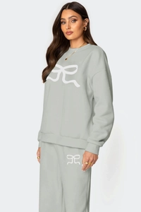 Détail d'un sweat-shirt à col rond avec nœud blanc et pantalon de jogging assorti