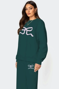 Détail de l'ensemble sweat-shirt ample et pantalon large avec imprimé nœud rose