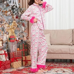 Detail of pink satin Christmas pajamas featuring festive prints and pink faux fur trim