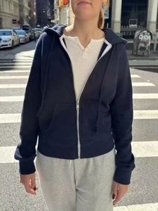 Navy blue zip-up hoodie for women, casual urban streetwear style on a city crosswalk