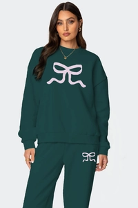 Détail de l'ensemble de détente vert forêt avec imprimé nœud rose et poignets
