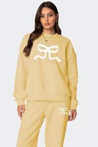 Détail de l'ensemble sweat et jogging jaune clair avec imprimés nœuds blancs épurés