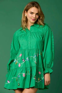 Detail of green long-sleeve dress with sequined Christmas lights and ruffled sleeves