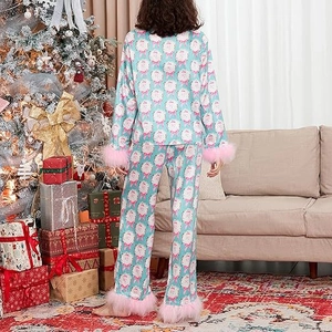 Rear view of Christmas pajamas with Santa print and pink plush trim in holiday setting