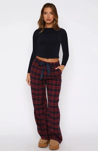 Close-up of women's black slim-fit T-shirt and red plaid lounge pants with waist bow detail