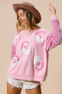 Detail of pink Christmas sweatshirt featuring sequin sleeves and Santa Claus embroidery