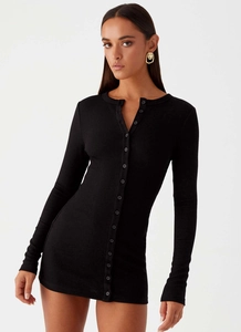 Detail of black ribbed knit texture and button-down front on a slim-fit long sleeve dress