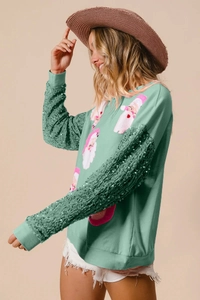 Detail of sequin sleeves and Santa Claus print on mint green Christmas sweatshirt