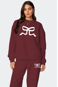Détail de l'ensemble bordeaux avec motifs nœuds blancs sur le sweat et le pantalon