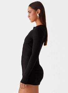 Detailed side view of black ribbed knit mini dress with vertical button design