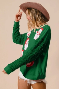 Detail of green Christmas sweatshirt featuring sequin sleeves and Santa Claus patterns