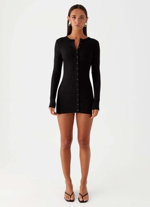 Detail of black ribbed knit slim fit long sleeve mini dress with front button closure