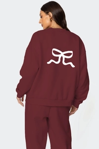 Détail de l'ensemble sweat rouge foncé avec un imprimé nœud blanc au dos du vêtement