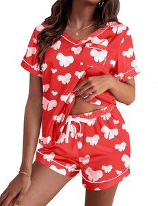 Detalle del pijama de satén rojo con cuello en V, estampado de lazos y ribetes en contraste