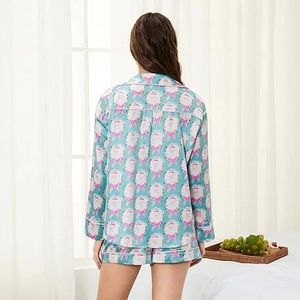 Rear view of light blue satin pajamas with cartoon prints and white piped edges