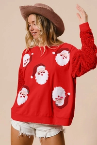 Close-up of red Christmas sweatshirt with Santa patches and sequined sleeves detail