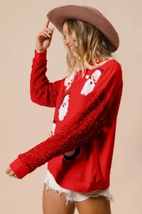 Detail of red Christmas sweatshirt featuring sequined sleeves and Santa Claus prints