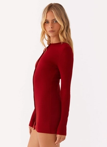 Detail of burgundy ribbed knit long sleeve bodysuit showing slim fit and round neck texture
