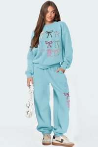 Detail of light blue tracksuit with colorful bow patterns and soft cotton fabric texture
