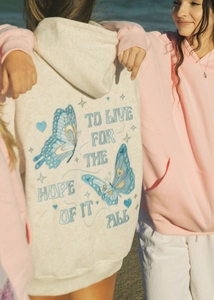 Detail of oatmeal hoodie with blue butterfly embroidery and hope slogan on the back