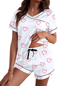 Detalle del conjunto de pijama de satén con estampados de corazones rosa y ribete negro