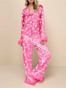 Pink satin Christmas pajamas with white nutcracker print and chic feather trim