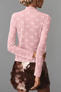 Detail of pink sheer lace top with bow patterns and brown sequined skirt from the back