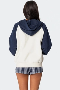 Vista posteriore di una felpa con cappuccio bicolore, corpo beige e maniche raglan blu