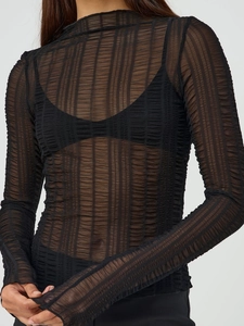 Detailed view of black sheer long-sleeve top with vertical textured mesh and high round neck
