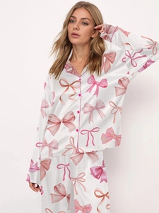 Women's satin pajama set featuring pink bow prints with long sleeves and pants