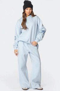 Détail d'un ensemble bleu clair avec imprimés nœuds aux manches et pantalon large