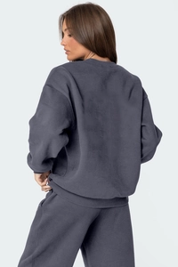 Side view of dark gray oversized sweatshirt and matching wide-leg pants set on model