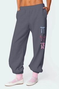 Detail of grey joggers with triple bow print, elastic waist and cuffed ankles