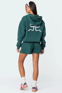 Vista posteriore di set felpa verde con stampa a fiocco rosa e pantaloncini con coulisse