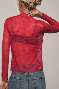 Detail of red sheer mesh top featuring bow patterns and a high neck design