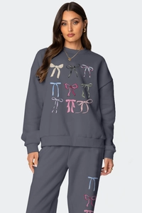 Detail of the crewneck sweatshirt set featuring colorful bow prints and rib-knit cuffs