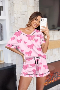 Detalle del pijama rosa con lazos, ribetes negros y pantalones con cordón ajustable