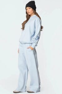Détail du survêtement bleu clair avec sweat à capuche et pantalon large à imprimés latéraux