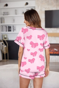 Detalle de la vista trasera de un pijama de satén rosa con estampado de lazos mujer