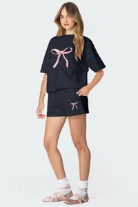 Détail d'un ensemble noir en coton avec imprimé nœud rose sur le haut à manches courtes