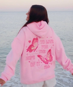Close-up of pink hoodie back featuring embroidered butterflies and artistic text