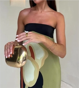 Dettaglio di una pochette in metallo dorato a forma di ciottolo tenuta da una modella