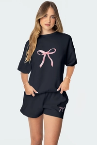 Détail d'un ensemble détente noir avec imprimés nœuds roses et tissu en coton doux