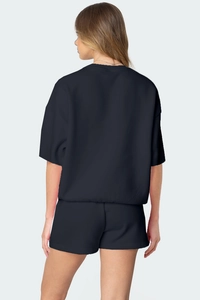 Vue arrière d'un ensemble deux pièces noir ample pour femme avec t-shirt et short