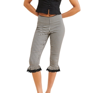 Close-up of black and white vichy plaid cropped pants with lace trim and ruffled hem