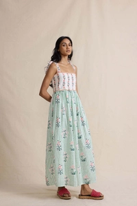 Detail of bohemian floral maxi dress featuring tie straps and a tiered striped patchwork design